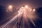 Highway at foggy night with bright trails of light from incoming and outgoing traffic