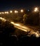 the highway is illuminated by numerous lamps, poles along the road, night and bright lighting
