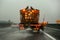 Highway maintenance gritter truck spreading de-icing salt, on the ice covered asphalt road during overcast day