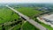 Highway near large warehouse and green field aerial view