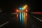 Highway at night in the rain with colored lights reflections on the asphalt