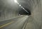 Highway road tunnel. Cars move in a tunnel through a mountain on a freeway.