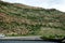 Highway through sandy mountains with sparse vegetation.