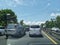 Highway situation shows traffic jam in the morning with couple of cars slowing down and green trees in sideways also blue sky