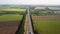 a highway stretching to the horizon among agricultural fields