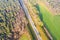 Highway surrounded by green forest. Autumn areal landscape