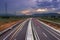 Highway to heavens with dramatic sky and car trails leading the way