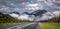 Highway to the rocky mountains with low hanging clouds and dramatic sky