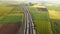 Highway with traffic in rural scenery. Suburban highway with cars and trucks. Travel and transportation. Aerial view