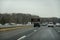 Highway view with cars and an SUV passing an electronic traffic warning sign that flashes Drive Sober or get Pulled Over.