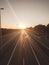 Highway view with little traffic, several cars and motorcycles, sunsets in the background