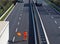 A highway worker with a high visibility work suit waves the orange flag to slow down trucks traffic before the roadblock