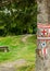 Hike marks painted on tree. Hiking signs. Hiking marks. Wooden table and bencj seen on the left. Red cross and on white square-