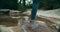 Hike tourist foot closeup crossing mountain river in forest on vacation travel