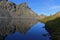 Hiker admires the view of early morning lights on blue mountain lake