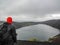 Hiker adventurer hiking in raincoat back standing outdoor looking crater lake in Laugaveur trek in stunning nature landscape,