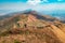 A hiker against a mountain background at Mbeya Peak in the Mbeya Mountain Range, Mbeya Region, Tanzania