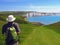 Hiker approaches white cliffs of Seven Sisters, East Sussex, England