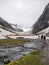 Hiker approaching campsite on a glacier after hard day of hiking