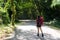 Hiker asia woman standing on forest trail and looking away in vacations day. Female with backpack and camping on hike in nature