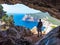 Hiker with backpack by a cave in Capo Caccia