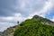 Hiker with backpack climbing on the mountain on a tourist path