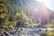 Hiker with backpack crossing mountain river. Hiking river crossing on the stones.