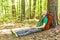 Hiker with backpack sleeping against a tree