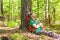 Hiker with backpack sleeping against a tree