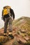 A hiker with a backpack standing on the top of the mountain