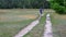 Hiker with backpack walking on a sandy country road in Ukraine at summer season