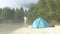 Hiker with binocular beside his tent