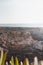 Hiker celebrates its success. Breathtaking cliffs with pebble beach in the afternoon sun on the Atlantic coast at Vila Nova de