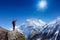 Hiker cheering elated and blissful with arms raised in the sky after hiking to mountain top summit