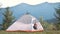 Hiker child boy resting inside a tent in mountain campsite enjoying view of nature.