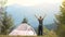 Hiker child boy resting near a tourist tent at mountain campsite enjoying view of beautiful summer nature.