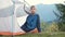 Hiker child boy sitting inside a tent in mountain campsite enjoying view of nature.