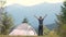 Hiker child boy sitting inside a tent in mountain campsite enjoying view of nature.