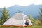 Hiker child boy sitting inside a tent in mountain campsite enjoying view of nature