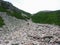 A hiker climbing a massive scree slope on the way to the summit