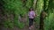 Hiker climbing up the path in mountain forest