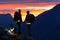 Hiker couple with dog holding hands and watching magical sunset sky