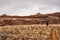 Hiker Crosing Desert Toward Rocky Shelf In Rain Storm