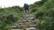 Hiker and dog climbing steep mountain