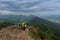 Hiker with dreadllocks on Maly Rozsutec, on background mountain village, Mala Fatra, Slovakia in spring cloudy morning