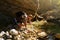 Hiker drinking water from the river. Man enjoys clean fresh unpolluted water in the mountain creek