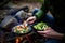 hiker eating a meal of steamed veggies by a campfire