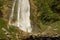 Hiker Enjoying the Scenic Waterfall with rainbow.