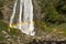 Hiker Enjoying the Scenic Waterfall with rainbow.