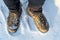 Hiker feet and boots on snowy trail